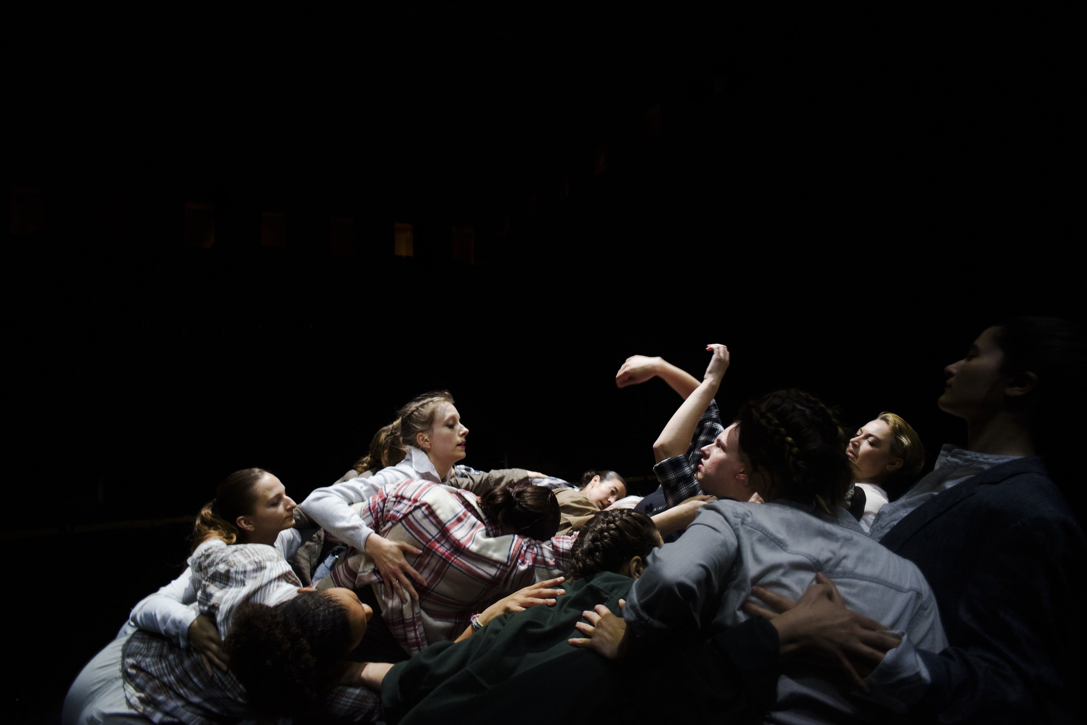 Groupe de danseurs au sol sur un plateau sombre