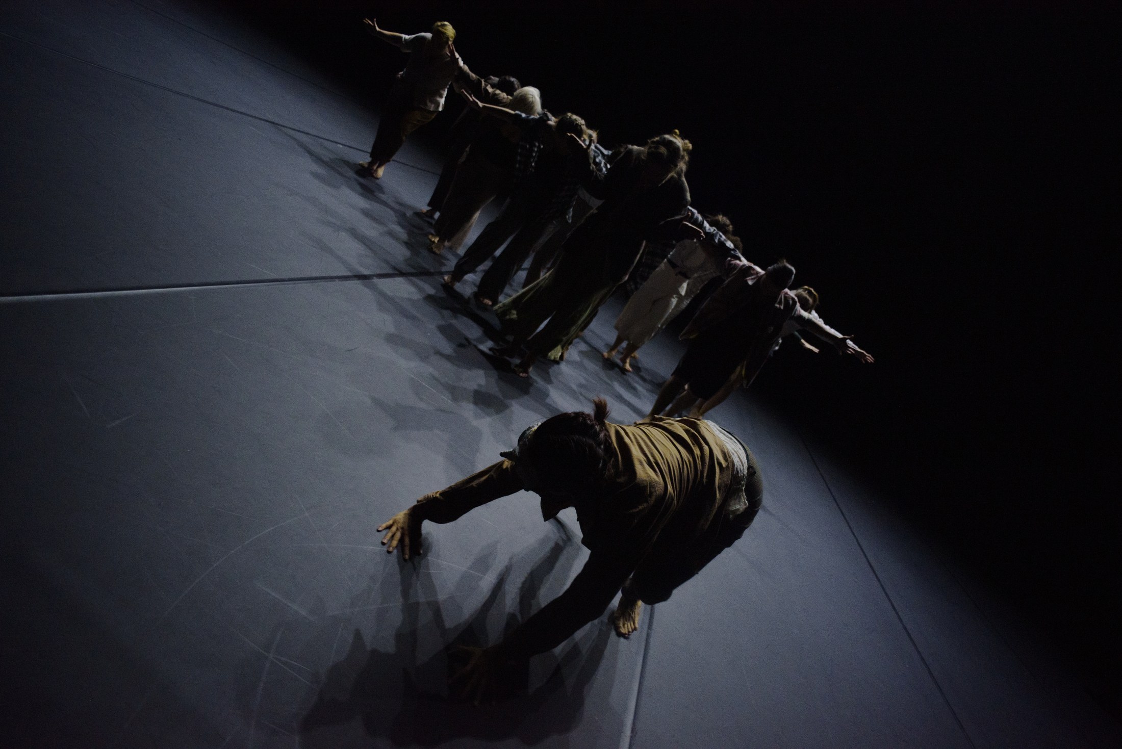 Groupe de danseurs en composition sur un plateau sombre